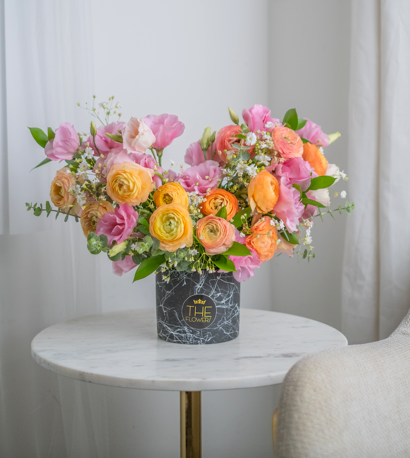 Orange ranunculus and pink lisianthus looks stylish and cheerful in a warm and sunny palette. This is a gift of pure positive emotions, which is associated with summer and the sun. Such a bouquet will perfectly cope with the task of raising the mood, and the atmosphere in the room that it will decorate.